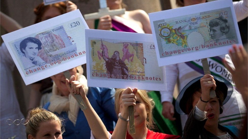 متظاهرات يحملن تصميمات لعملات ورقية عليها صور سيدات
