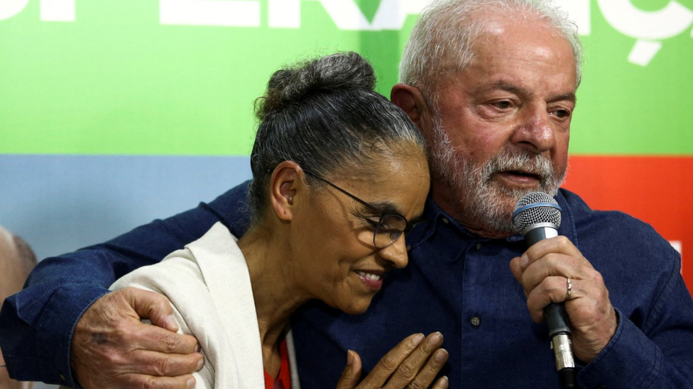 Lula e Marina sorrindo e abraçados em evento