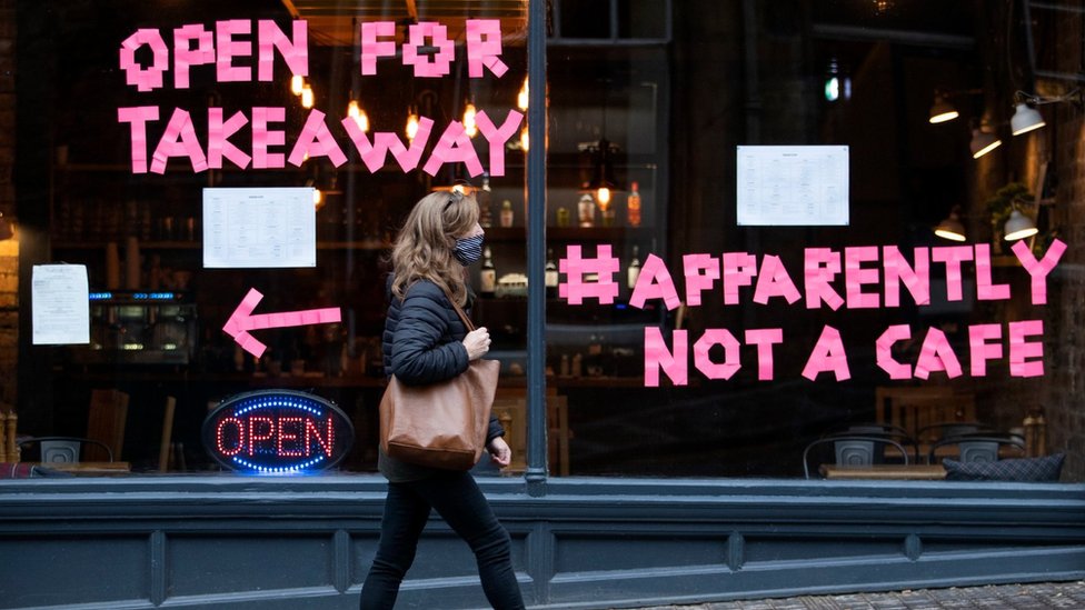 Woman walking past cafe