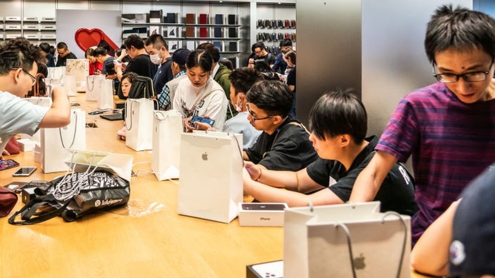 Покупатели активируют новые смартфоны серии iPhone 11 после покупки в розничном магазине Apple на East Nanjing Road в Шанхае. Apple начала продажи своей последней серии iPhone 11 в Китае.