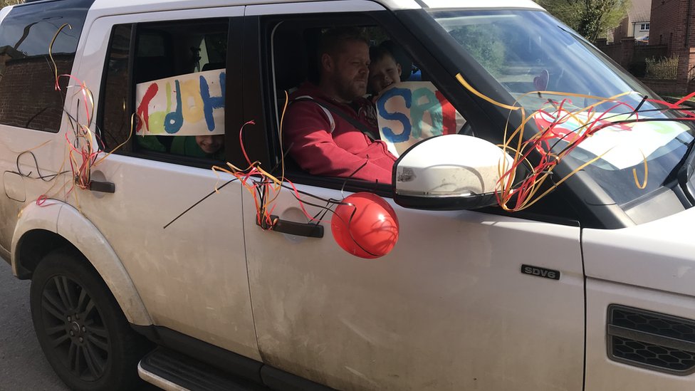 Автомобиль украшен баннерами на день рождения и воздушными шарами.
