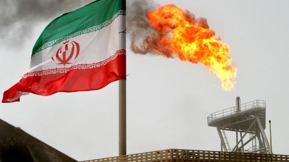 Una bandera de Irán junto a instalaciones energéticas