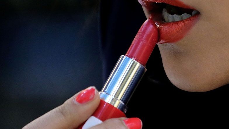 Iranian woman applying lipstick