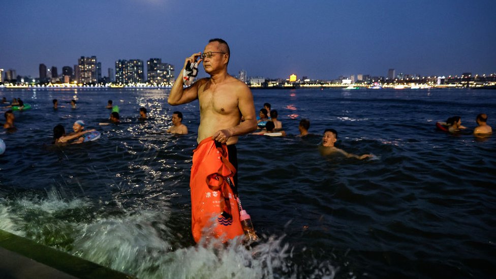 People swim in the intersection of the Han and Yangtze rivers during the heatwave in Wuhan, Hubei province on 10 August