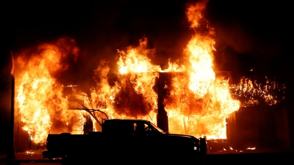 A car is seen in front of a fire during a demonstration against the death in Minneapolis