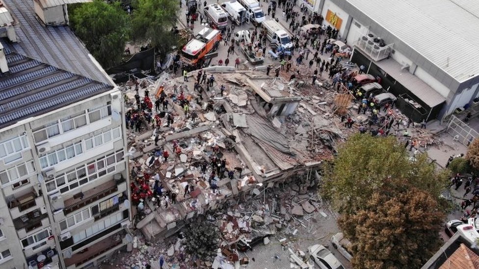 Rescuers inspect the ruins of a building demolished by the earthquake in Izmir.