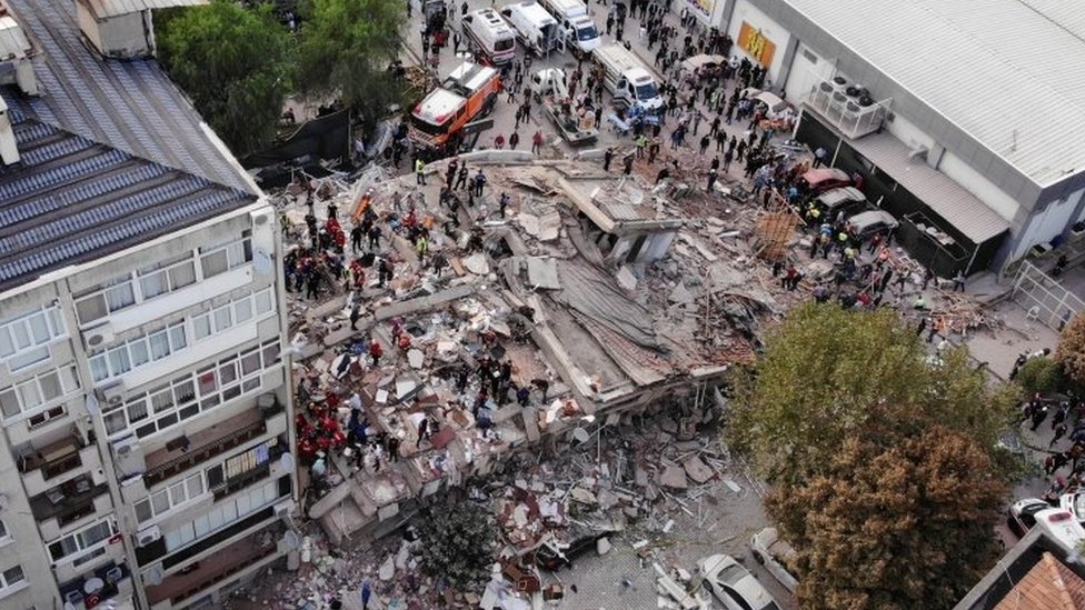 Rescatistas inspeccionan las ruinas de un edificio derribado por el sismo en Esmirna.