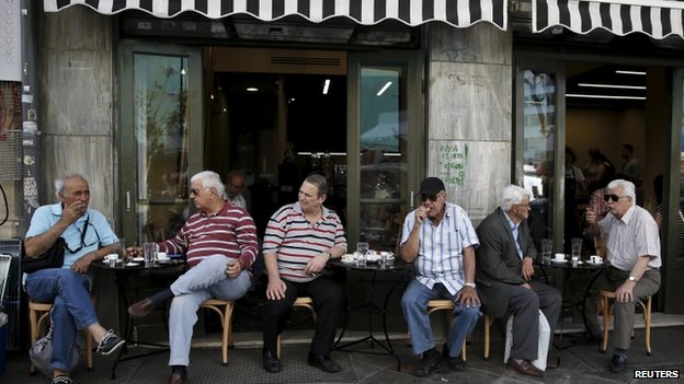 Мужчины сидят возле кафе в Афинах