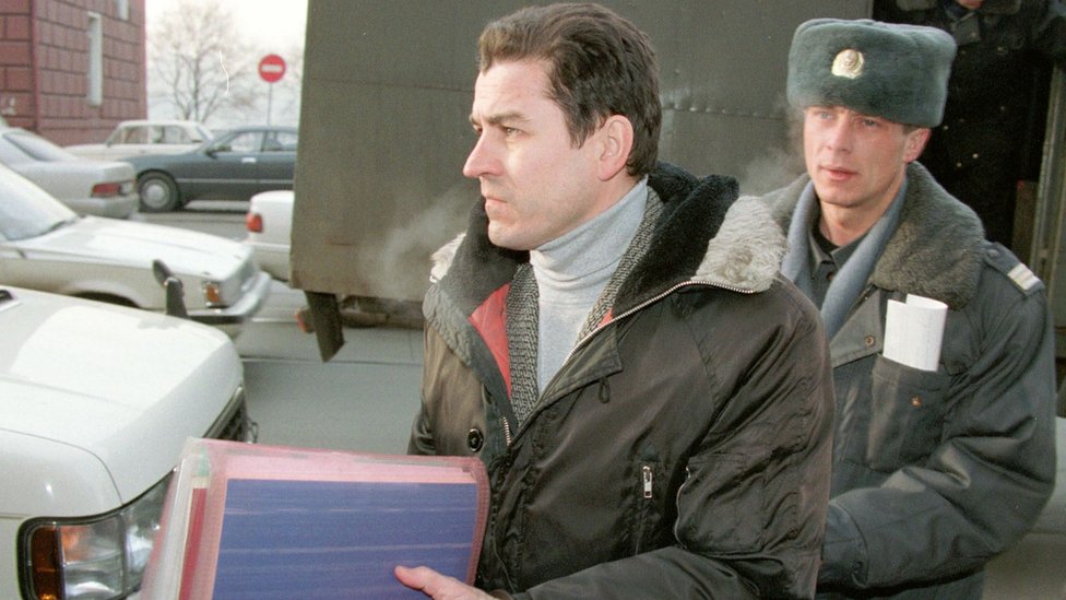 Военный журналист Григорий Пасько (слева) выходит из машины в сопровождении милиционера по прибытии в суд Владивостока 21 января 1999 г.