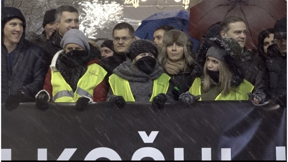 Demonstranti na čelu kolone uvijeni u šalove i kape zbog jakog snega
