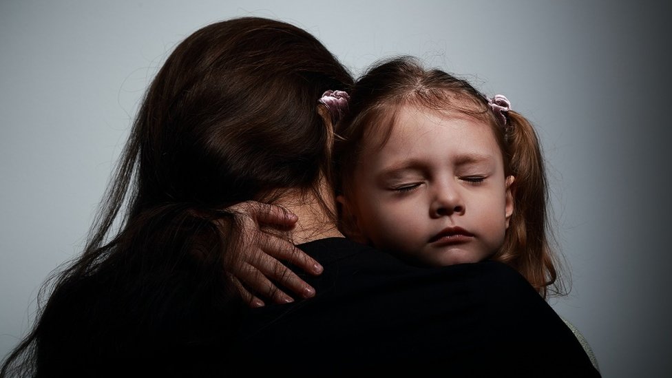 Una madre abrazando a su hija.