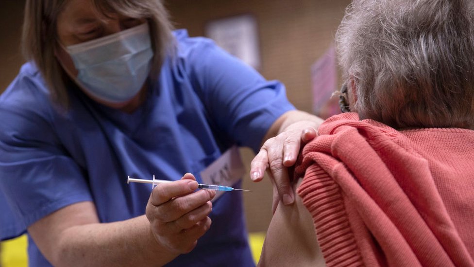 Mulher idosa sendo vacinada