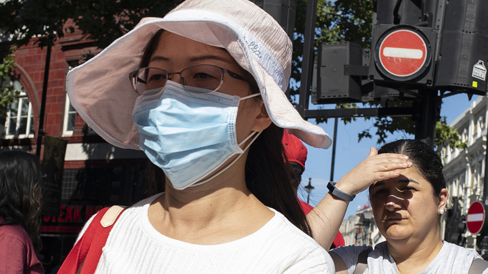 Изображение женщины в маске, защищающей от загрязнения окружающей среды в Лондоне