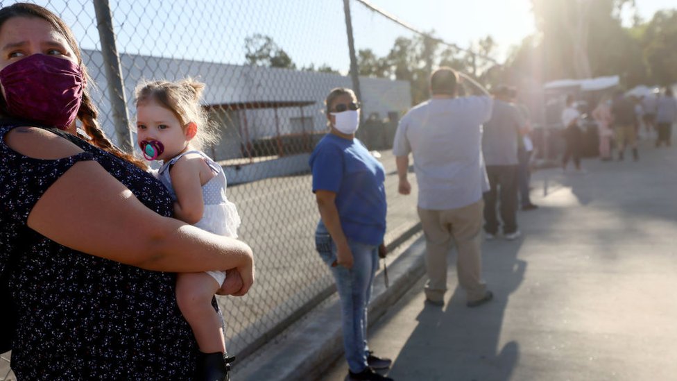 A woman holds her niece while waiting in line at a walk-up Covid-19 testing site on December 2, 2020 in San Fernando, California