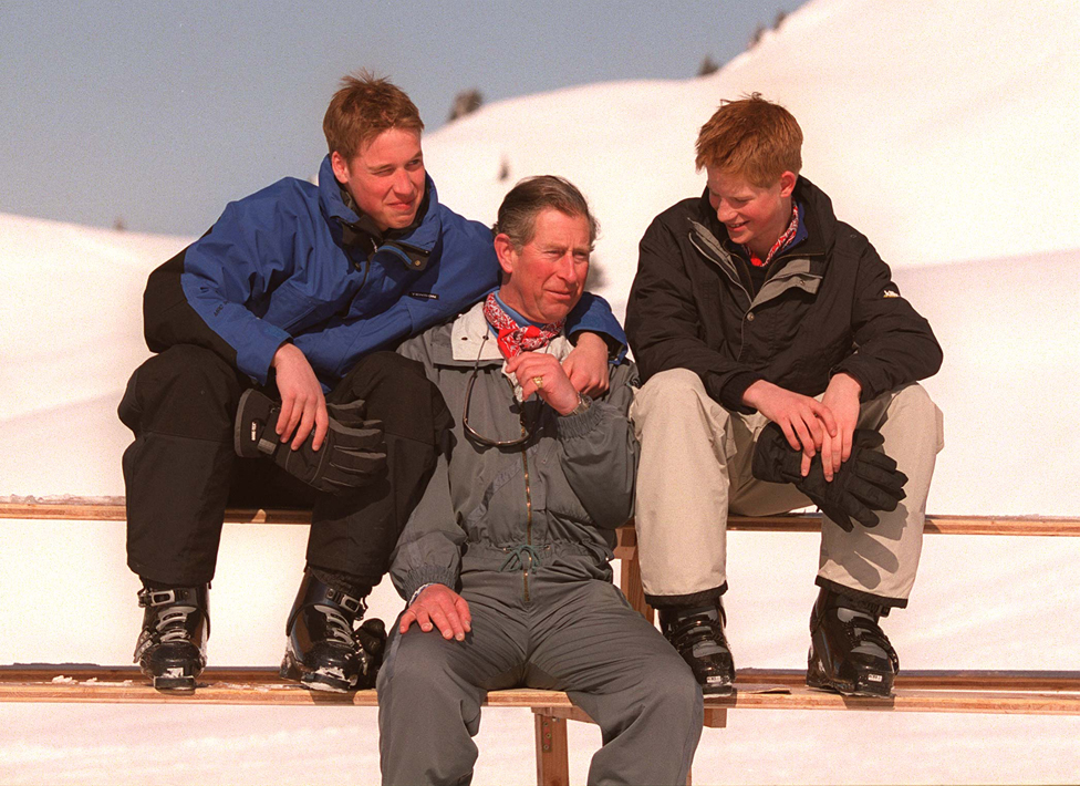 El rey Carlos III con sus hijos, el príncipe William, a la izquierda, y el príncipe Harry, durante sus vacaciones privadas de esquí en Klosters, Suiza, el 6 de abril de 2000.