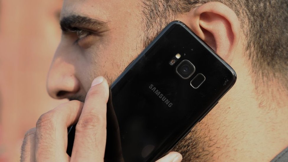 Un hombre sostiene un teléfono Samsung.
