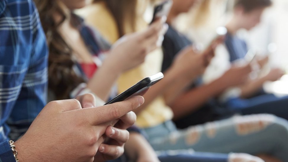 A stock image of kids looking at phones