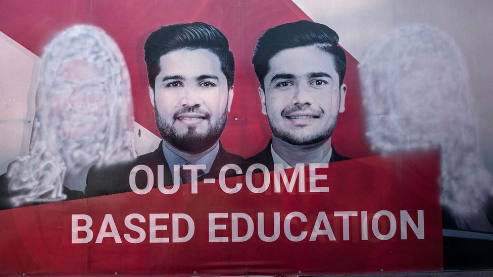 A banner seen with images of women defaced using spray paint are pictured inside a private university