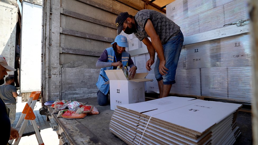 موظفو الأمم المتحدة يتحققون من محتوى شاحنات المساعدات قبل عبورهم إلى سوريا