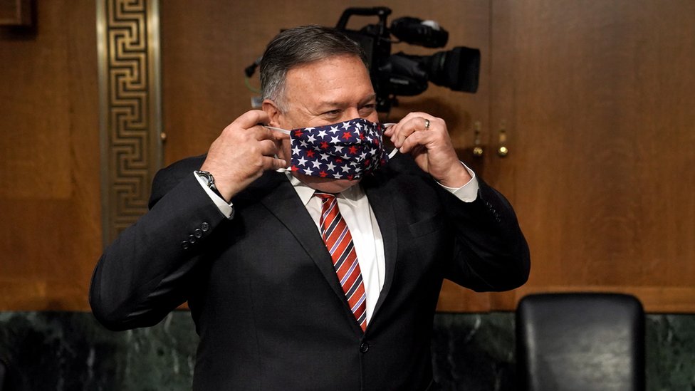 Госсекретарь США Майк Помпео надевает маску на лицо