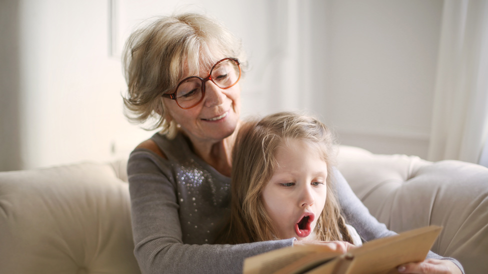 Abuela leyendo junto a su nieta