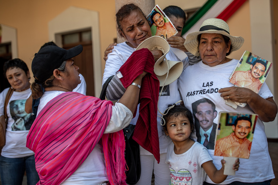 Una familia con fotos de su familiar desaparecido en una protesta en El Fuerte.