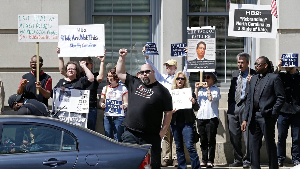 Противники Дома Билла 2 протестуют через дорогу от Капитолия штата Северная Каролина в Роли, штат Северная Каролина