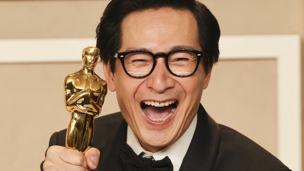Ke Huy Quan smiling with his Oscar