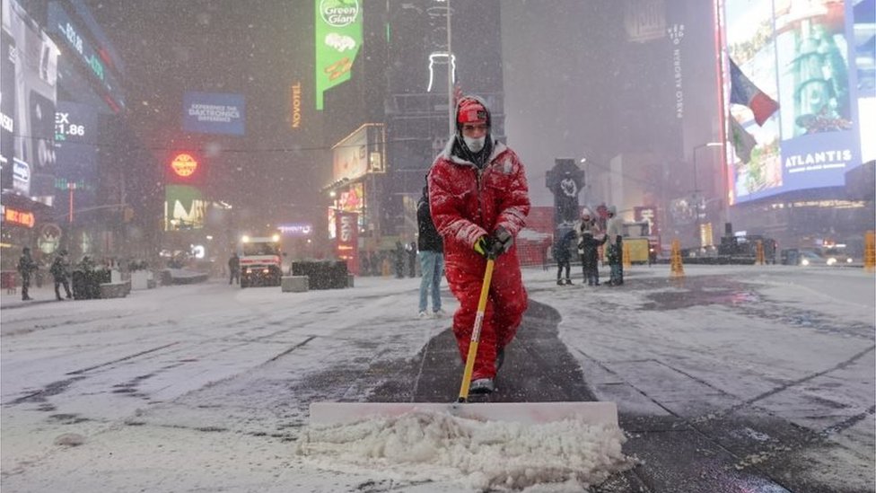 A worker clears snow in Times Square