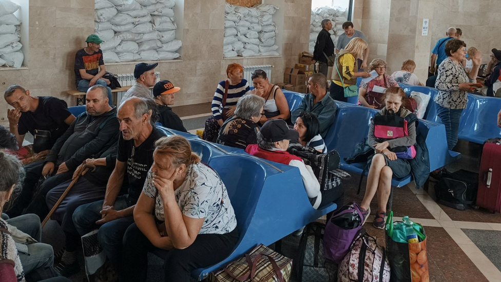 Los residentes locales esperan un tren de evacuación en una estación de Jersón.