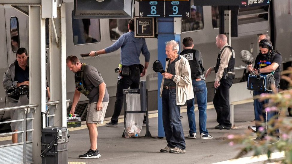 Американский кинорежиссер Клинт Иствуд (в центре) стоит на платформе во время съемок фильма