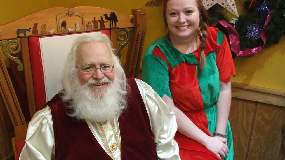 Papá Noel, o Santa Claus, con una de sus ayudantes Santa Claus con una de sus ayudantes