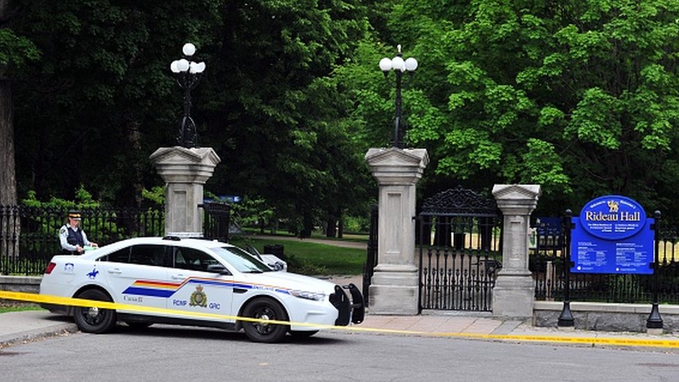 Entrada principal al Rideau Hall en Ottawa, con un auto de policía estacionado afuera.