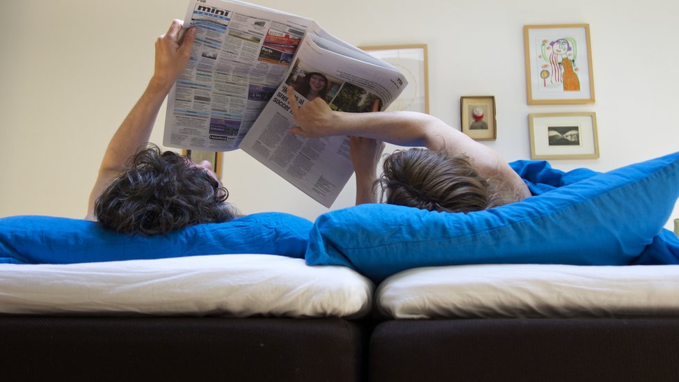 Пара, читающая газету