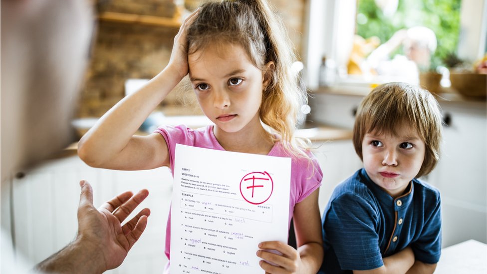 niña con examen que suspendió