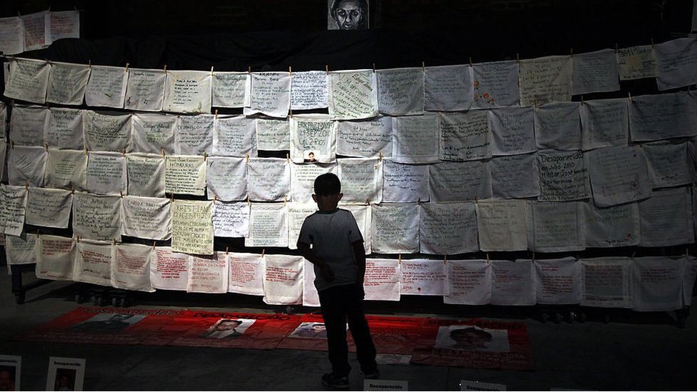 Un niño lee nombres de víctimas de violencia en pañuelos bordados en Guadalajara, México. Noviembre de 2013.