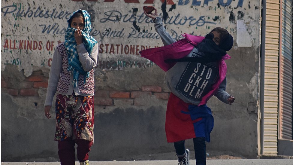 Протестующая женщина бросает камни во время столкновений в Сринагаре, Кашмир, 29 октября 2019 г.