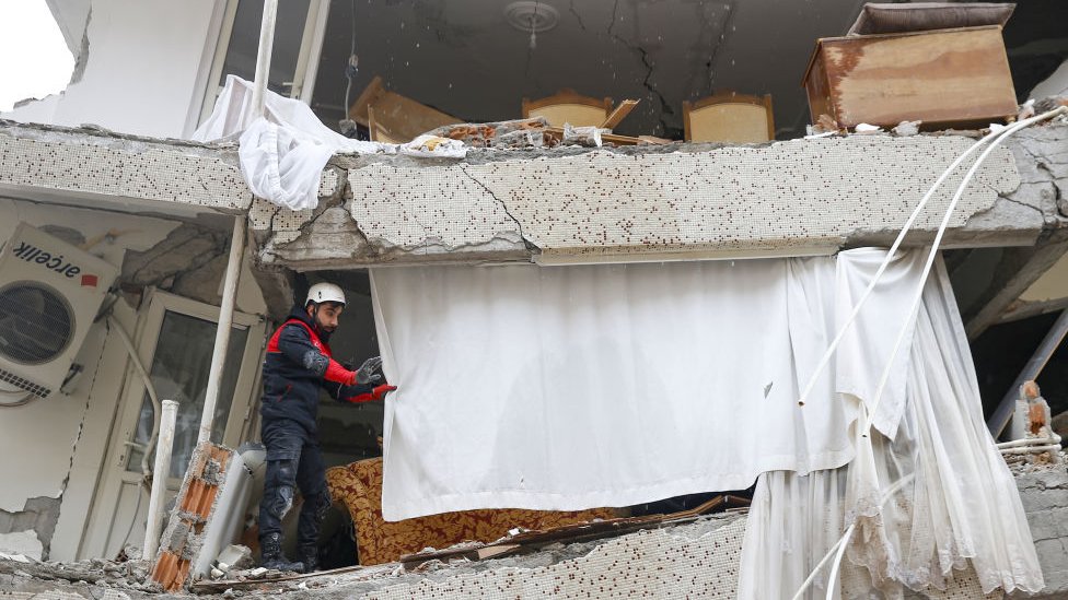 رجل يقف في بناية تضررت بالزلزال