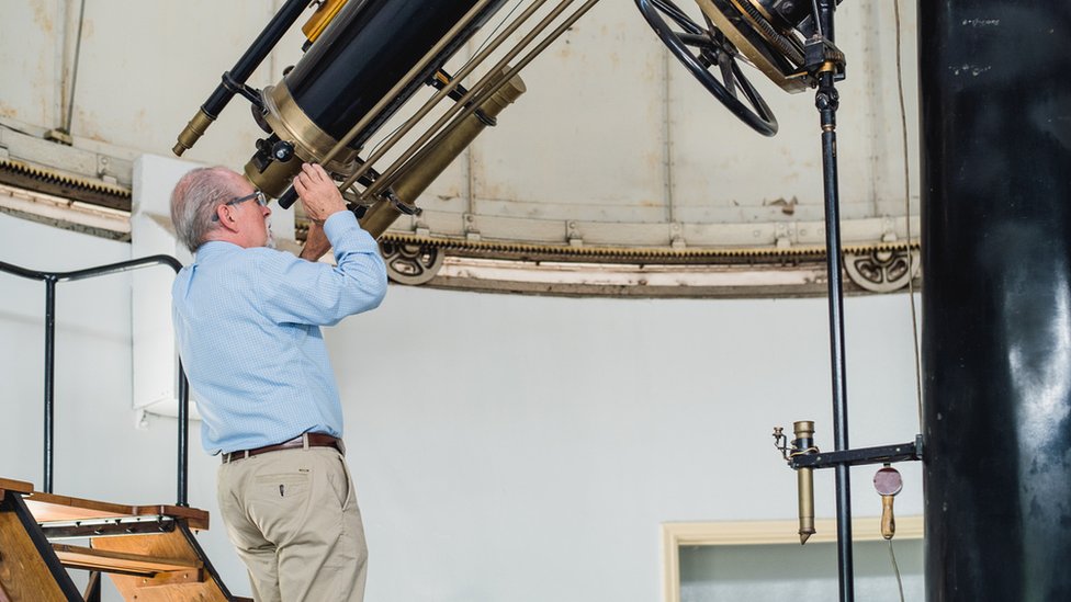 José Maza mirando por un telescopio