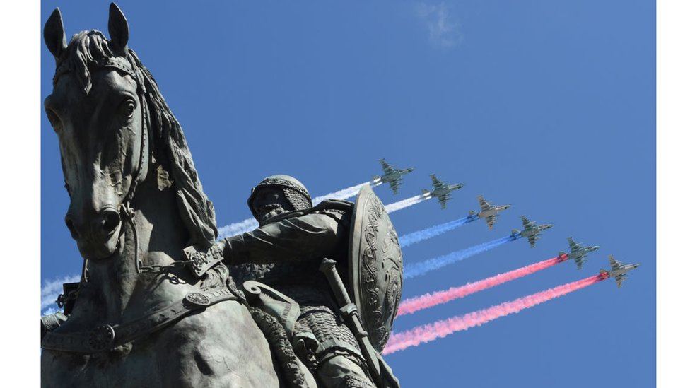 Cazas Su-25 dejan estelas con los colores de la bandera rusa ante una estatua del príncipe ruso Yuri Dolgoruky durante los ensayos del desfile del Día de la Victoria.