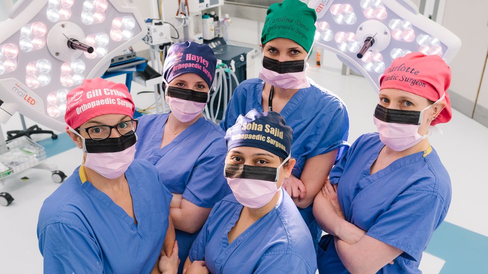 Женский хирургический персонал носит защитные шапочки