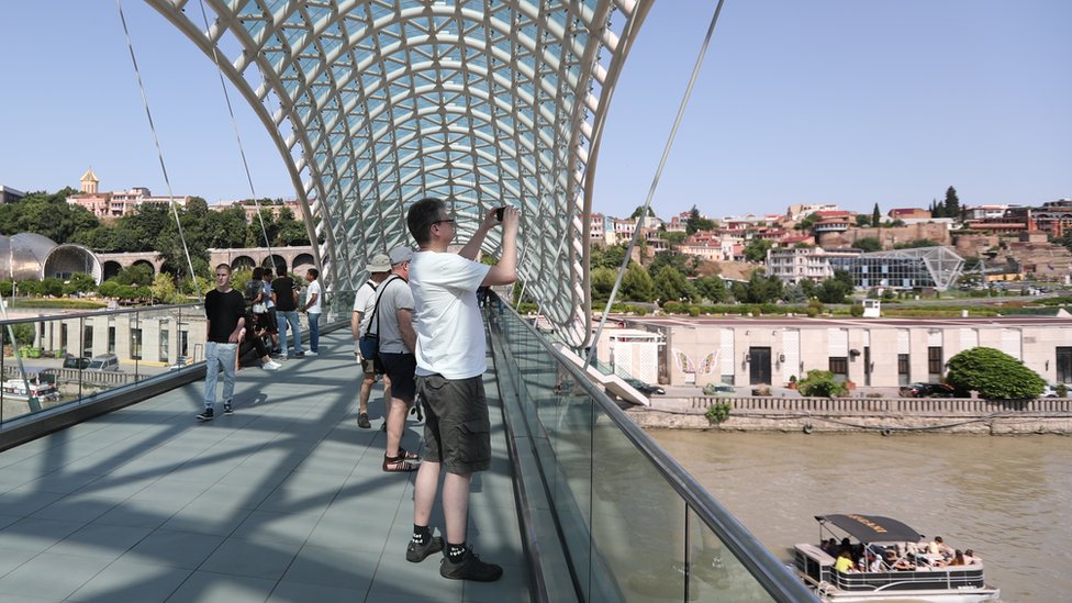 Туристы посещают Мост Мира в старом городе Тбилиси, Грузия 23 июня 2019 г.