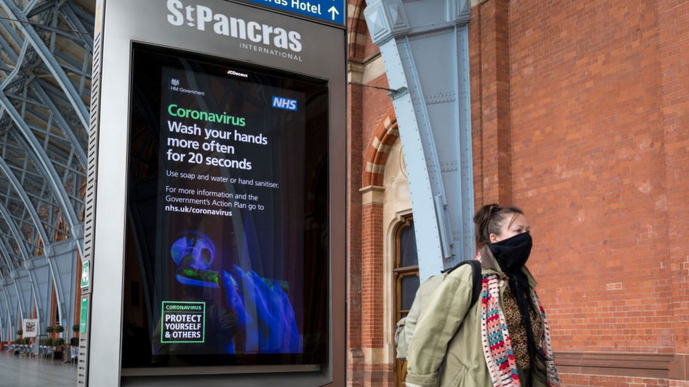 Женщина в маске покидает станцию ??St Pancras International