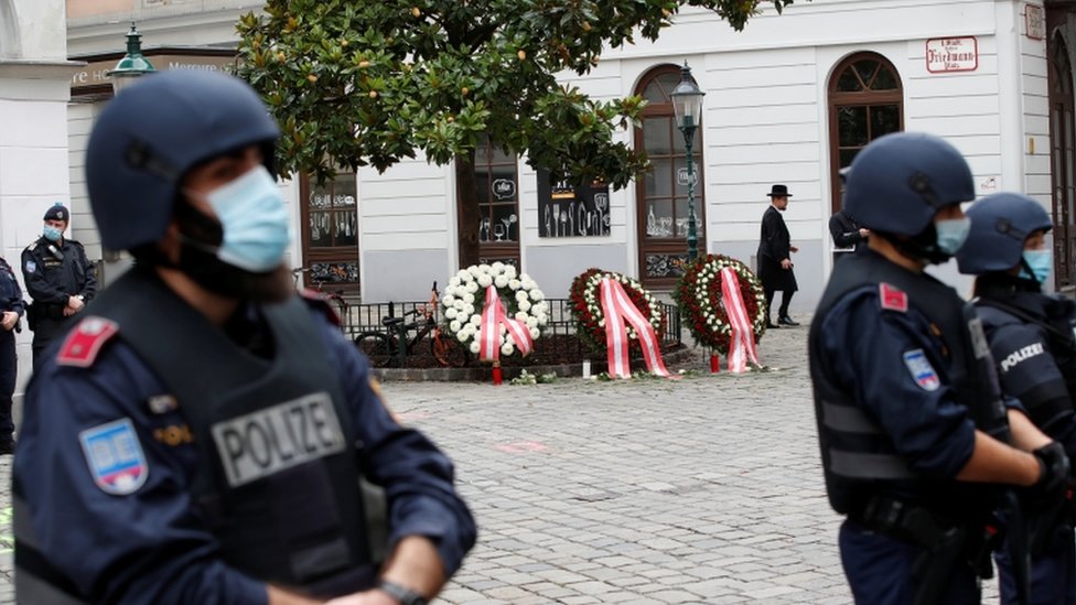 Police officers stand guard at the site of a wreath laying ceremony after a gun attack in Vienna,