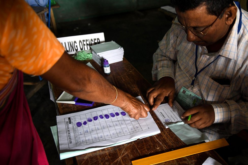 An Indian voter gives her fingerprint as she comes to cast her vote at a polling station during India`s general election