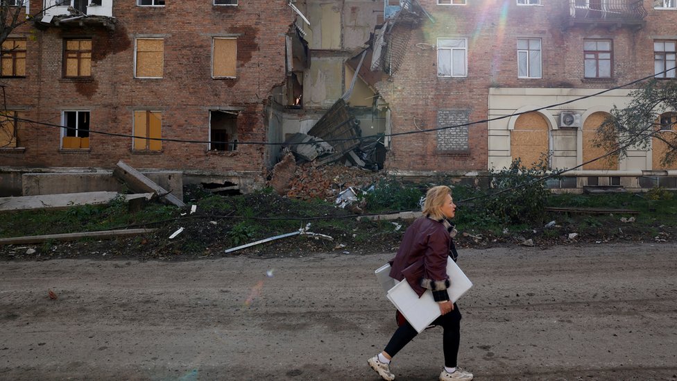 Žena prolazi pored ruševina zgrada u istočnom Donbasu