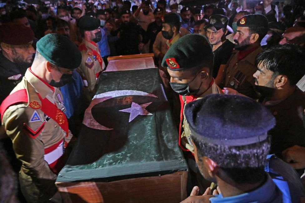 Soldiers prepare to place the flag-draped coffin of nuclear scientist Abdul Qadeer Khan during his funeral