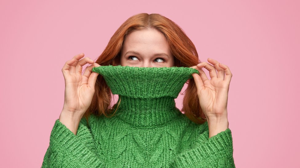Una mujer con un sweater verde.