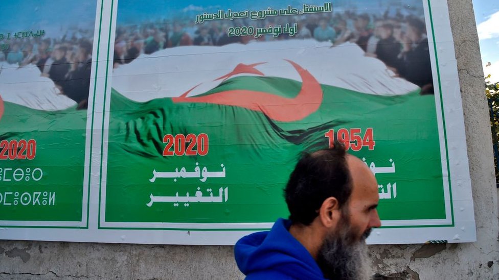 A man walks past a billboard for constitutional amendments