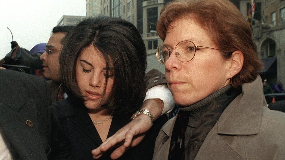Монику Левински сопровождают через прессу в Вашингтоне в 1999 году